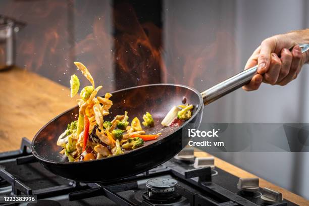 Chef Tossing Flaming Vegetable Stock Photo - Download Image Now - Cooking, Chef, Frying Pan