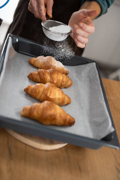 istock Chef sprinkling powdered sugar on croissants 1223383999
