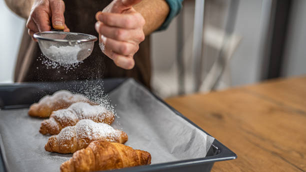 istock Chef sprinkling powdered sugar on croissants 1223384001
