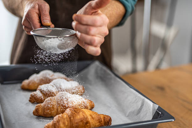 istock Chef sprinkling powdered sugar on croissants 1223384003