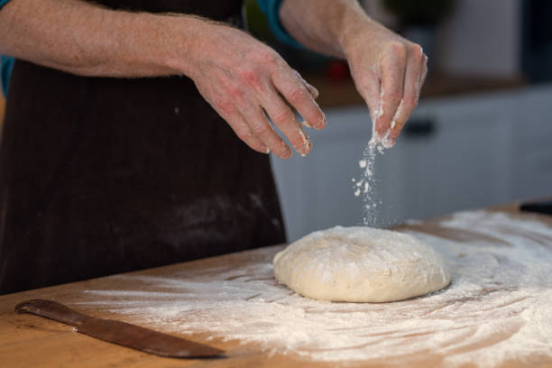 istock Chef sprinkling flour onto a dough ball 1223384022