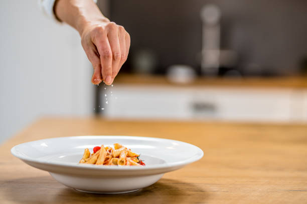 istock Chef sprinkling salt onto pasta dish 1223384048