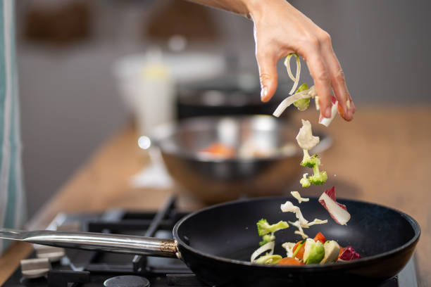 istock Dropping vegetables into a frying pan 1223384053