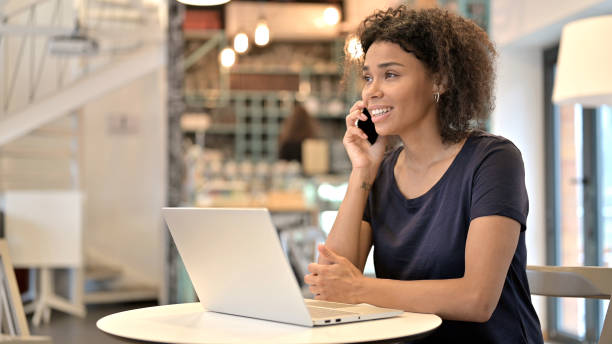 istock Young African Woman Talking on Smartphone in Cafe 1223385457
