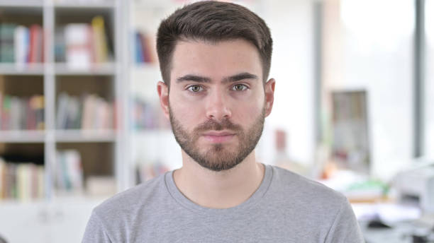 istock Portrait of Serious Young Man Looking at Camera 1223385590