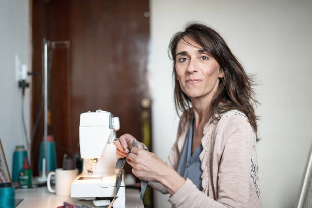 portrait of woman sewing at home - sewing tailor sewing machine women imagens e fotografias de stock