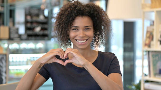 istock Smiling African Woman making Heart Shape 1223385969