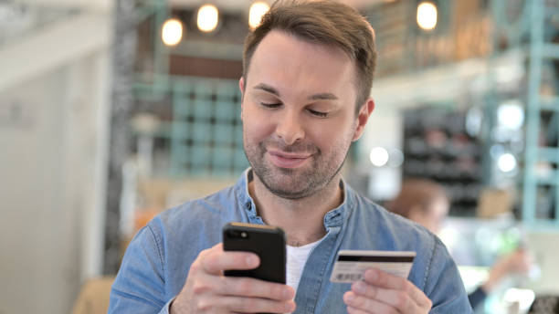 istock Online Shopping on Phone by Satisfied Happy Man 1223386973