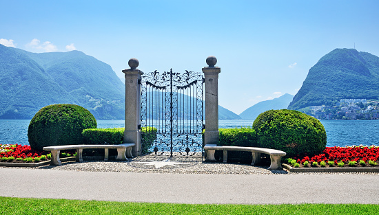 Decorative gate to the pier on Lake Lugano in public botanical park of the city Lugano, Switzerland