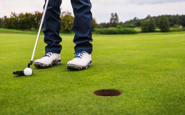 pelota de golf golpeando en verde y cayendo en el agujero - putting down fotografías e imágenes de stock