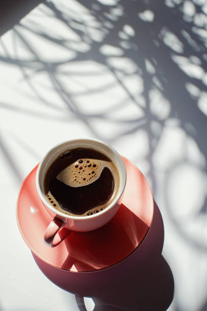 istock aromatic black coffee in a pink cup in the morning on a white background with shadows 1223390881