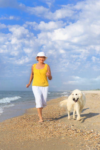 istock Elderly woman running with her golder retriever 1223390925
