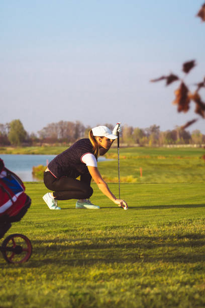 młoda piękna kobieta trenuje golfa jesienią - golf green practicing sports training zdjęcia i obrazy z banku zdjęć