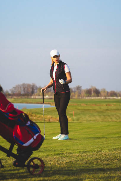 młoda piękna kobieta trenuje golfa jesienią - golf green practicing sports training zdjęcia i obrazy z banku zdjęć