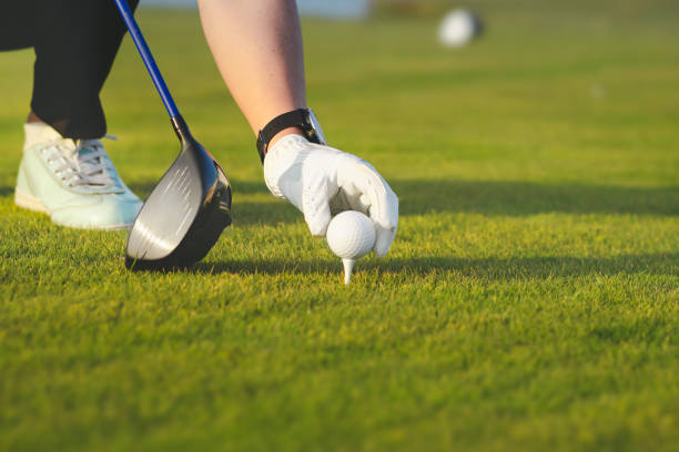 istock female hand placing golf ball on tee 1223391153