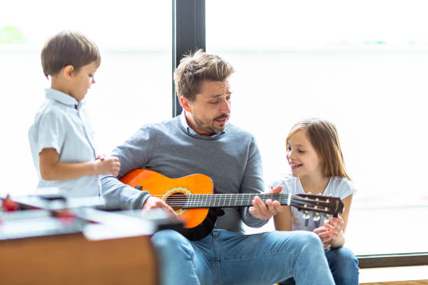 istock Father and kids playing guitar 1223392064