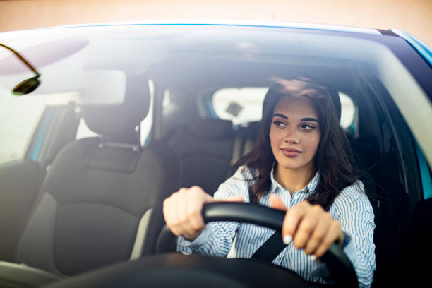 istock Happy woman driving a car and smiling 1223392968
