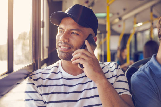 공공 버스에서 스마트 폰으로 말하는 남성 승객 - bus commuter passenger mobile phone 뉴스 사진 이미지