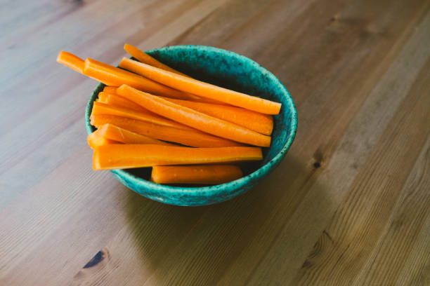 Healthy snack, raw carrots, sliced into sticks in a ceramic bowl - healthy snack, healthy eating habits, children snack, raw vegetables for raw food diet stock photo