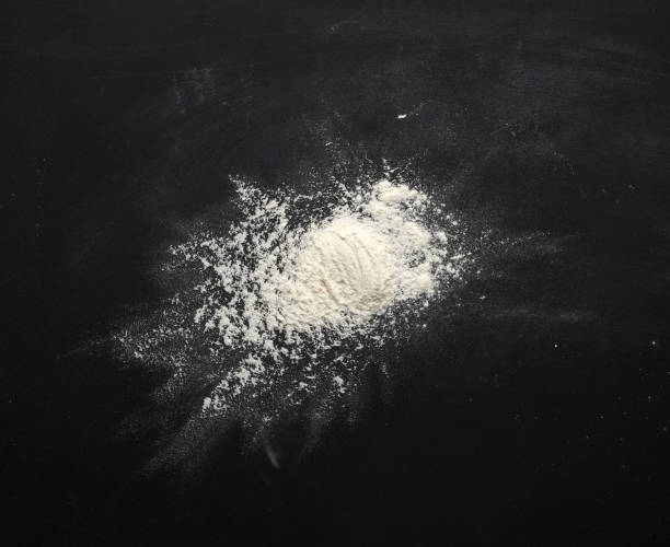 istock white wheat flour scattered on a black table, ingredient for the dough 1223395457
