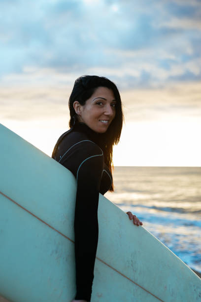 istock Young woman standing with her surfboard on the beach 1223395495