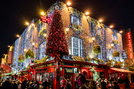 Crowd of people in front of the famous Temple Bar Pub in Temple Lane, now decorated for Christmas. It is located in the Temple Bar quarter in Dublin, the capital city of Ireland.