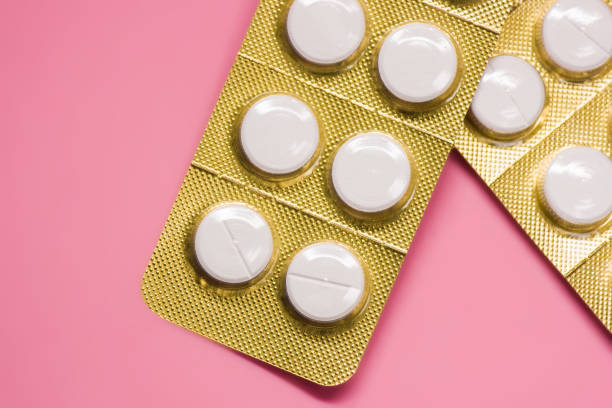 istock white sealed pill packages with pink background 1223403212