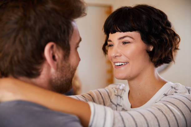 istock Young woman laughing while standing with her arms around her husband 1223403370