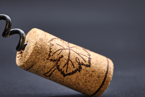 Close-up corkscrew with a cork. dark background