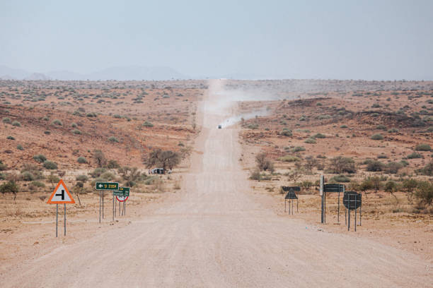 Cars kick up dust on the C35 gravel road in Tsiseb region, Namibia, Africa stock photo