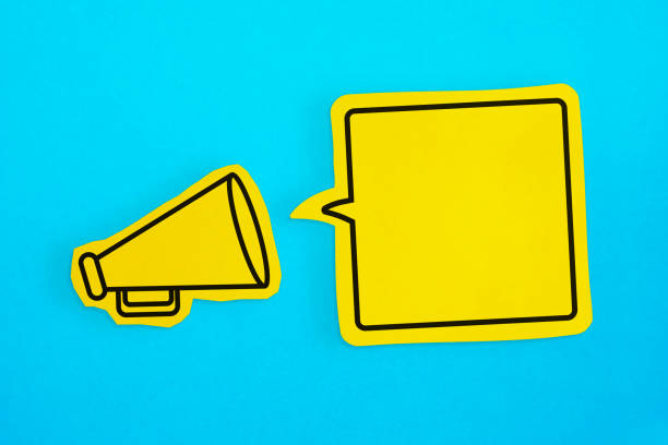 Megaphone drawing on the cut yellow paper makes announcement with empty speech bubble.