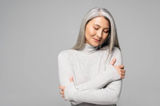 dreamy asian woman in turtleneck with grey hair and closed eyes isolated on grey dreamy asian woman in turtleneck with grey hair and closed eyes isolated on grey older woman eyes closed stock pictures, royalty-free photos & images