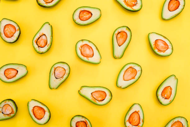 istock Avocado natural color and condition divided in half on a yellow background. 1223412956