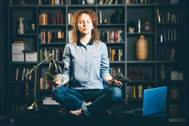 Photo of yoga meditation with dollars banknotes