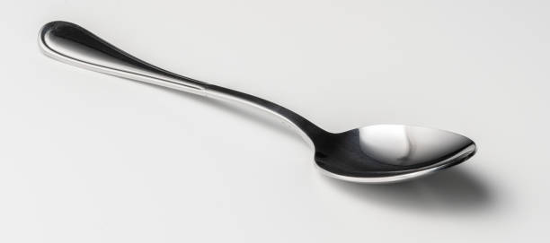 istock Silver dessert spoon cutlery on grey background 1223415283