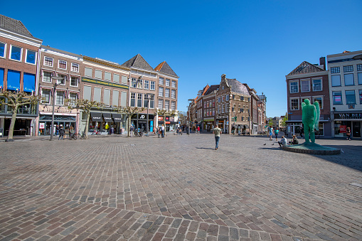 ZWOLLE, THE NETHERLANDS - APRIL 19, 2020: Quiet Grote Markt shopping street in the city center of Zwolle, Overijssel, The Netherlands. Few people are visiting the shopping street during the Corona crisis.