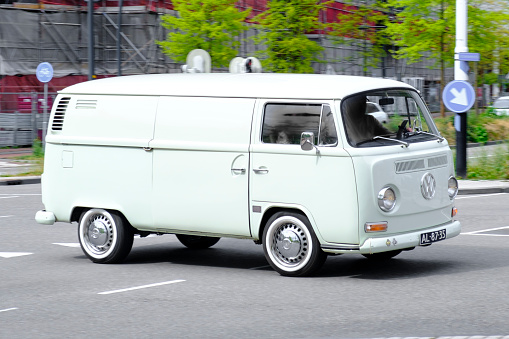 1970s classic Volkswagen Transporter T2 van driving on the road in Zwolle, The Netherlands during a springtime day. The second generation of the Volkswagen Type 2 (T2) was built from 1967–1979 by VW in Europe, built remained in production longer in Mexico, Argentina and Brazil until 2013.