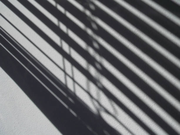 istock Diagonal shade from blinds on white wall background 1223417469