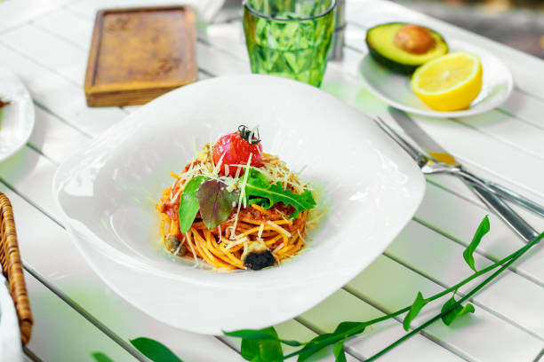 istock Italian pasta with cheese and vegetables on a white plate 1223421909