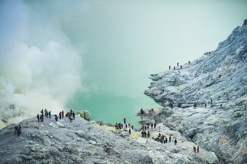 Sulfur lake and smoking mine mountain and green lake in the morning at Kawah Ijen volcano Indonesia