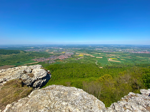 Panoramic picture from the Somló Hill to a village and agricultural fields on a cloudy day in springtime. Also there are some hills in the background.
