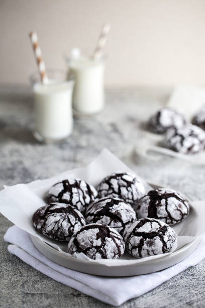 chocolate cookies. homemade chocolate crinkles cookies powdered sugar with milk stock photo
