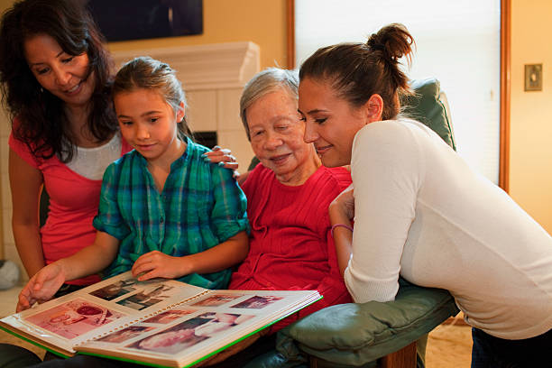 Three generation family looking at photo album  washington state photos stock pictures, royalty-free photos & images