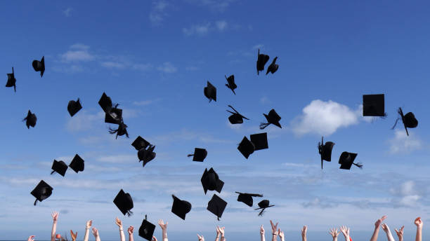 istock Graduation celebrations, throwing caps into a blue sky 1223427521