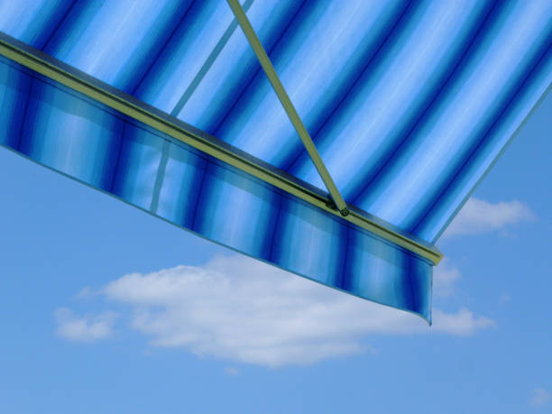 blue and white canvas awning detail. blue sky and cloud stock photo