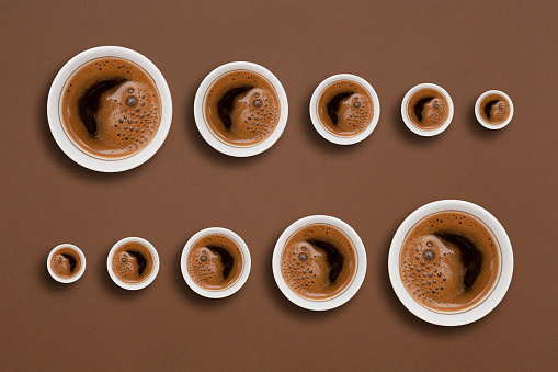 Coffee cups with hot coffee  photographed from above on brown background