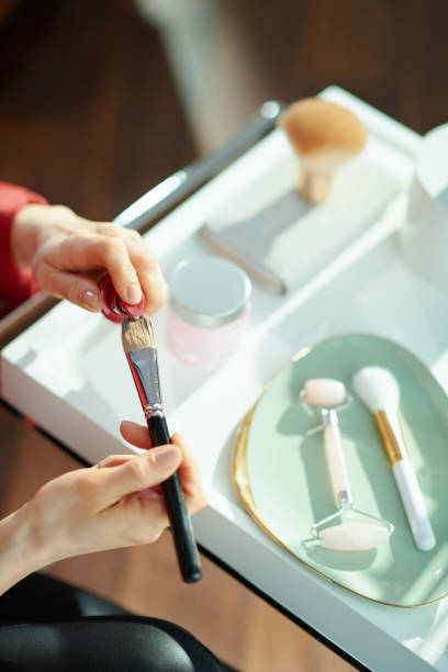 istock modern female putting liquid foundation on cosmetic brush 1223430364