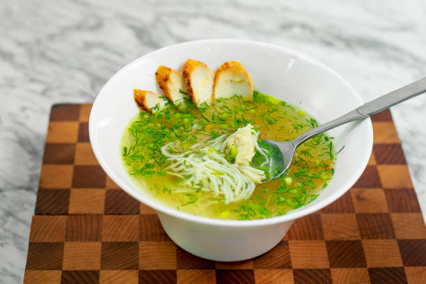 istock soup with chicken, mushrooms and herbs on a white plate, a beautiful serving 1223432349
