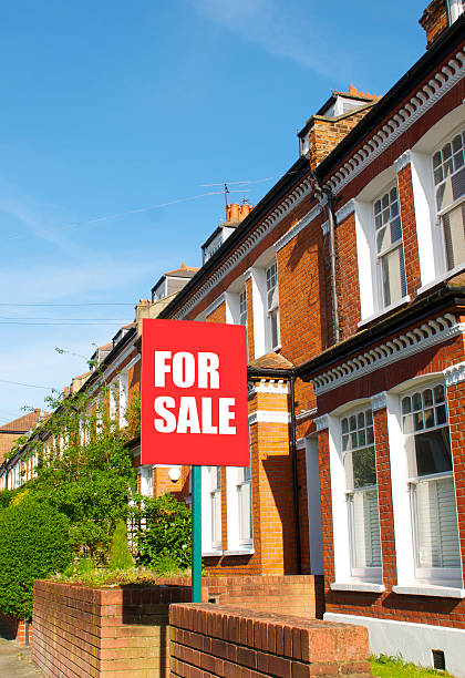 For sale sign in front of a brick building stock photo