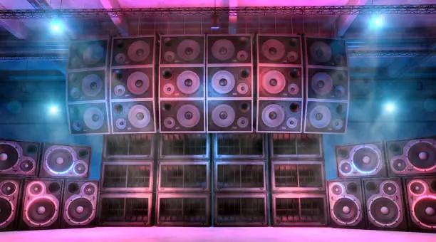 Loudspeakers and subwoofers stacked on each other on a music concert stage illuminated by blue and magenta lights, with foggy and smokey atmosphere. Punk and hard rock music background. Powerful sound system. Digitally generated image.